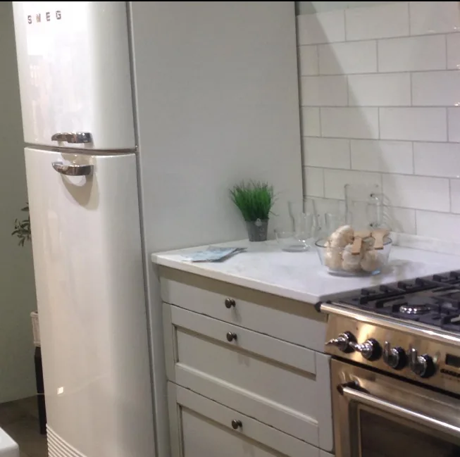 Cocina de estilo clásico con muebles blancos y electrodomésticos vintage